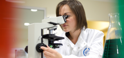 Asbestos analyst looking into a microscope